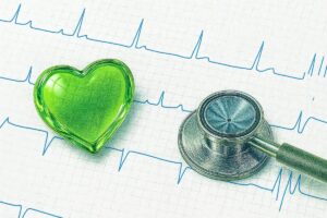 心電図の上に、聴診器とハートの模型が置いてあります