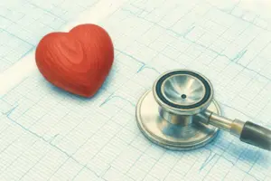 ハートの模型と聴診器が心電図の上に置いてあります。
