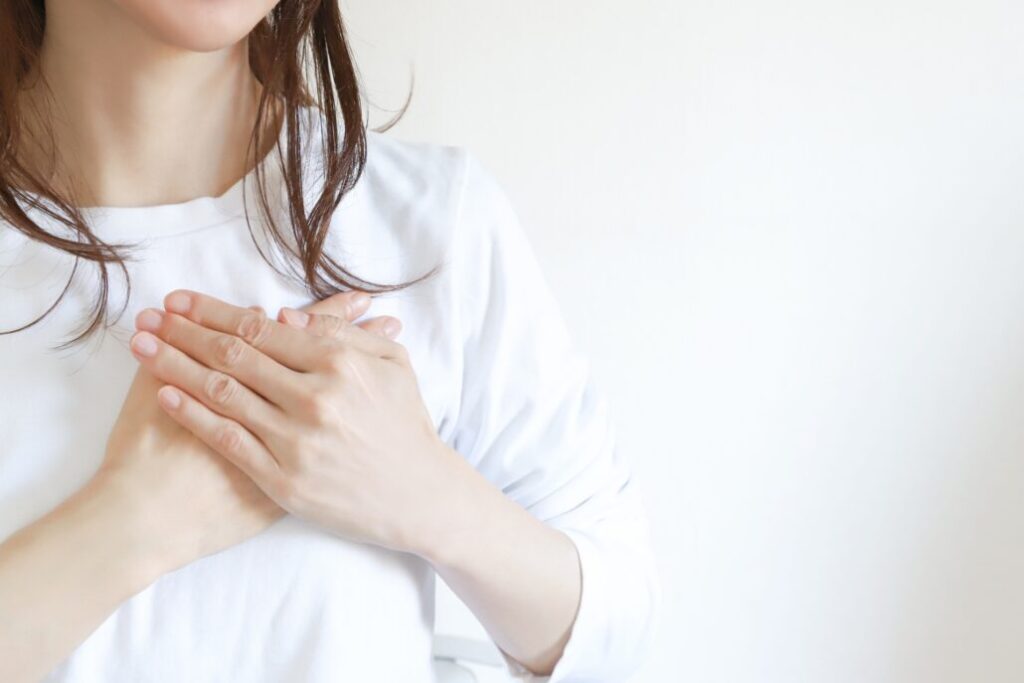 心筋梗塞を発症し、胸を抑える女性